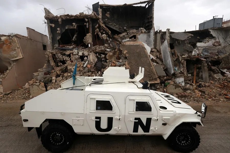 Un vehículo blindado de la Fuerza Provisional de las Naciones Unidas en el Líbano (UNIFIL) circula junto a edificios destruidos en Meiss al-Jabal, distrito de Marjayoun, sur del Líbano, en una fotografía de archivo. EFE/EPA/Wael Hamzeh.