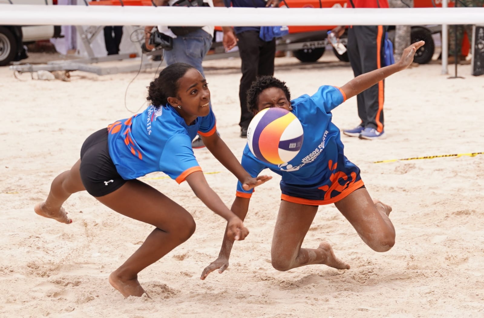 Dos jugadores se lanzan para tratar de salvar el balón en uno de los partidos de voleibol de playa en Boca Chica.