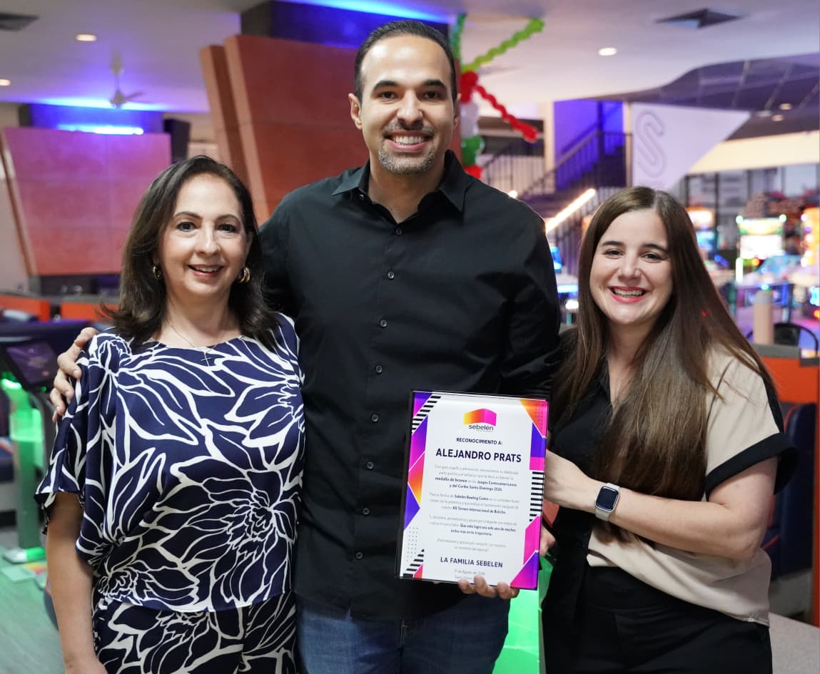 Alex, acompañado de su madre Bettina Morey y su esposa Carmen, exhibe orgulloso el certificado de la dedicatoria del Torneo Internacional de Boliche del SB.